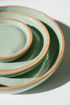 A large stack of ceramic cups in pastel green color. Stock Photos