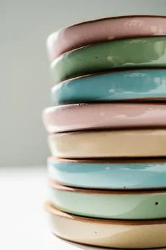 A large stack of ceramic cups in pastel colors. Stock Photos