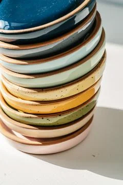 A large stack of ceramic cups in pastel colors. Stock Photos