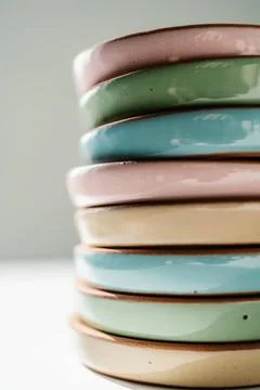 A large stack of ceramic cups in pastel colors. A large stack of ceramic c... Stock Photos