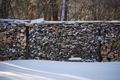 Large stack of cut firewood covered with snow during winter. Outdoor wood s.. Stock Photos