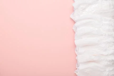 A large stack of disposable diaper panties on a pink background with a place  Stock Photos