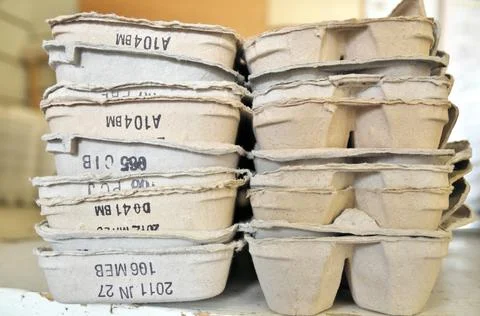 A large stack of empty egg cartons on a table at a farm that sells local eggs Stock Photos