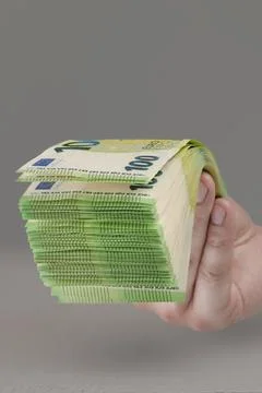 Large stack of euros in hand. Banknotes of 100 euros in a male hand on a uniform Foto stock
