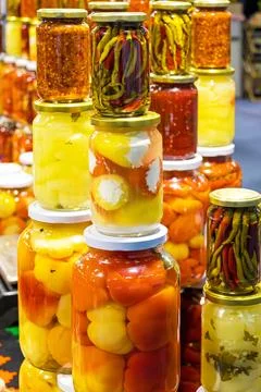 Large stack of fermented vegetables inside glass jars sold on market place Stockfoto's