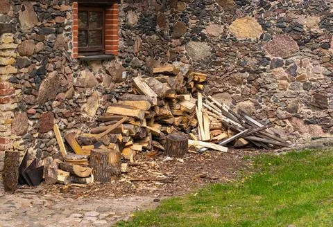 Large stack of firewood with axe resting on top in rustic outdoor setting. Stock Photos