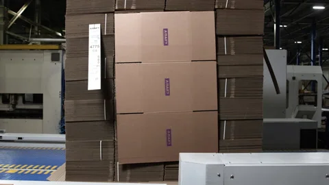 Large stack of folded cardboard boxes at production line Stock Footage 241892073