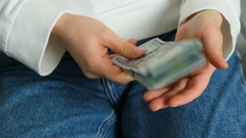 A large stack of hundred-dollar bills in his hands, tapping a stack of money on Stock Footage 295770429