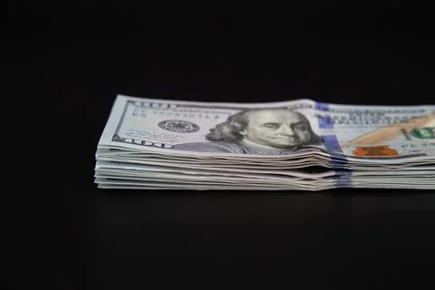 Large stack of hundred dollar bills on a black background. Stock Photos