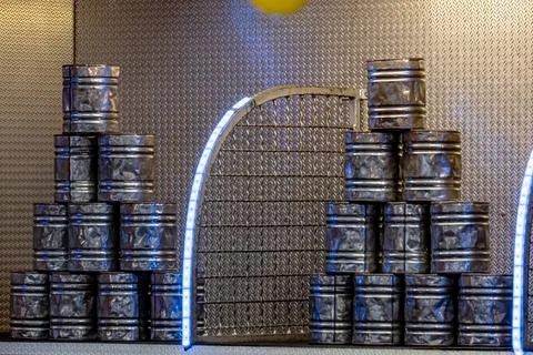 A large stack of metal barrels with a small door in the middle Stock Photos