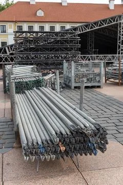 Large stack of metal scaffolding pipes and clamps on racks Stock Photos