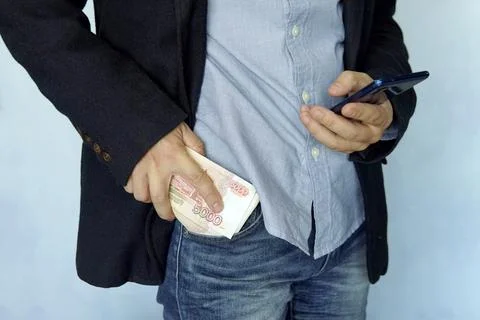 Large stack of money with modern smartphone in the pocket of old vintage jean Stock Photos