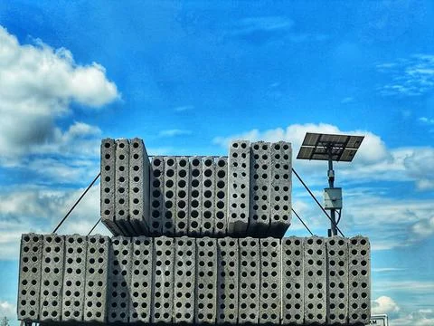 A large stack of perforated concrete blocks arranged on a flat surface under  Stock Photos