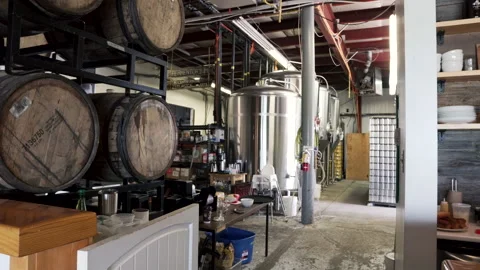 A large Stack of whiskey barrels in the back of a craft brewery in 4K with Stock Footage 277377870