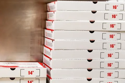 A large stack of white pizza boxes with red numbers. Stock Photos
