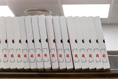 A large stack of white pizza boxes with red numbers. Stock Photos