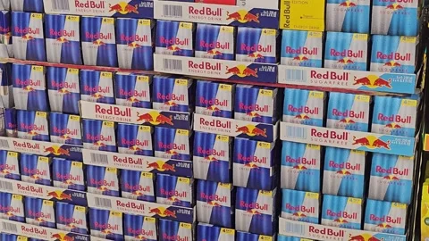 Large stacked display of various Red Bull energy drink four-packs and multi-pa 스톡 동영상 341459779