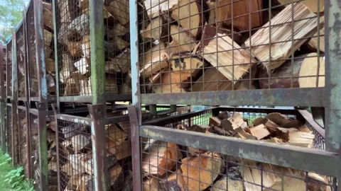 Large Stacks of Split Firewood Stored in Metal Storage Cages Stock Footage 340337818