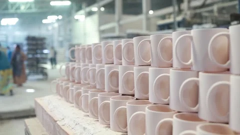 Large stacks of unfinished ceramic mugs are neatly organized on a production Stock Footage 327422204