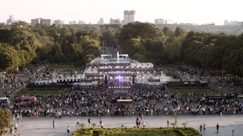 A large stage for a performance in a park near fountains in a big city. The Stock Footage 169587989