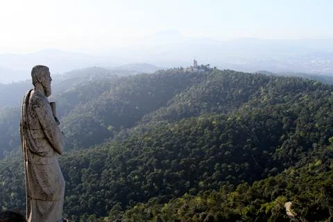 Large statue looking over beautiful green hill landscape Stock-Fotos