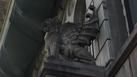 A large statue of a winged bird is installed on the side of a building, creating 動画素材 311068213