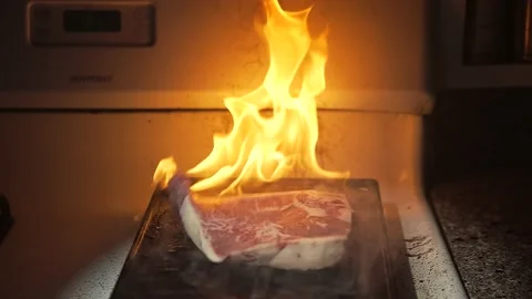 Large steak drops slow motion on flaming flat top Stock Footage 152798739