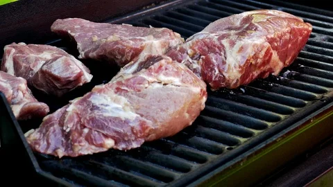 Large steaks are placed on a hot grill Stock Footage 89457134