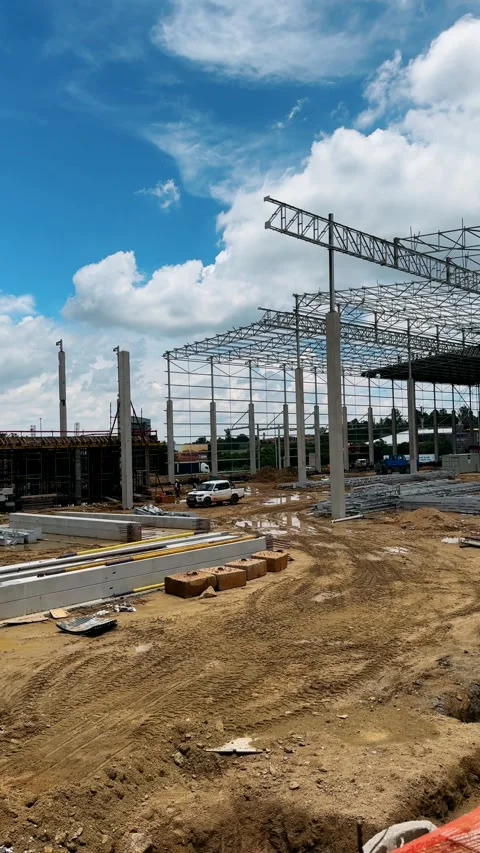 Large steel frame warehouse construction with aerial view of expansive factory s Video stock 324183408