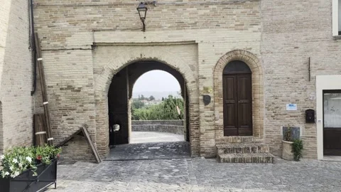 Large stone arch that opens onto a rural panorama Stock Footage 344107852
