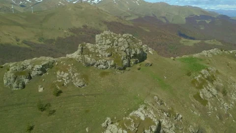 Large stone block with a man, Wind turbines and antenna. Pushkin Pass Armenia. Stock Footage 254461470
