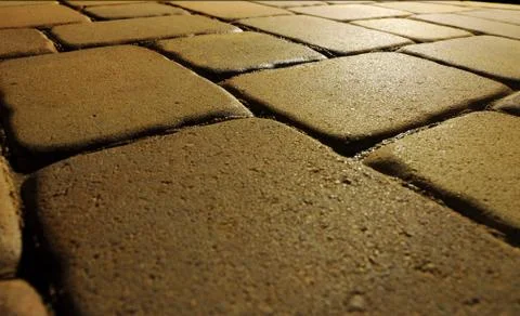 Large stone blocks on the ground lit at night. the depth of field is somewhat Stock Photos