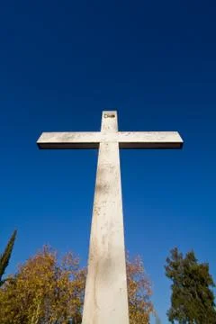 Large stone cross against clear blue sky Stock Photos