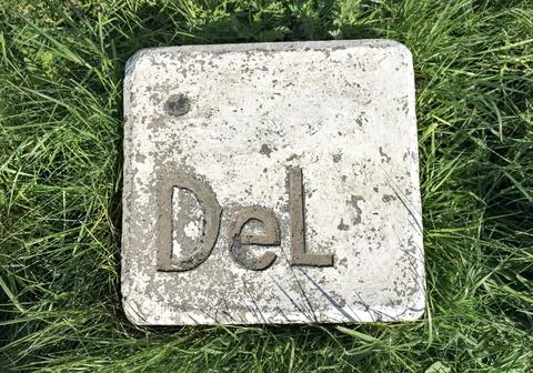 Large stone installation button delete makes an imitation computer key on grass Stock Photos