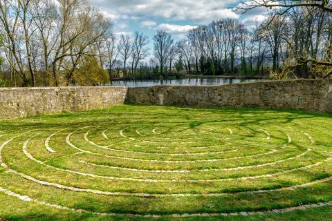 A large stone ring in a meadow with an old stone wall in the background Stock Photos