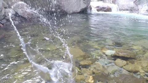 Large stone skipping in crystal clear mountain river 4 times slow motion Stock Footage 91470355