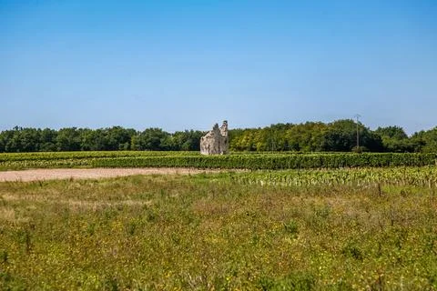 A large stone structure is in the middle of a field in France Stock Photos