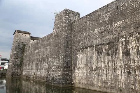 A large stone wall with a tower in the middle Stock Photos