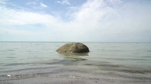 Large stone in water with small ripple, calm 库存影片 155877187