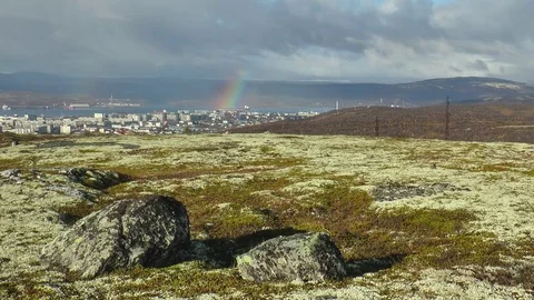 Large stones in a mossy plain against a river and сity in the distance. Video stock 75069376