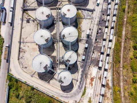 Large storage tanks and train tracks at an industrial site during daytime hou Foto stock