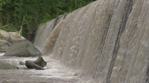 A large stream that falls into a short waterfall Stock Footage 234941114