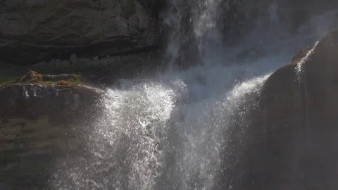 A large stream of water falls and smashes against the rock in the sun 스톡 동영상 78046798