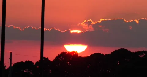 Large sun set with around orange glowing sun pink sky outer Banks North Carolina Video stock 234595042