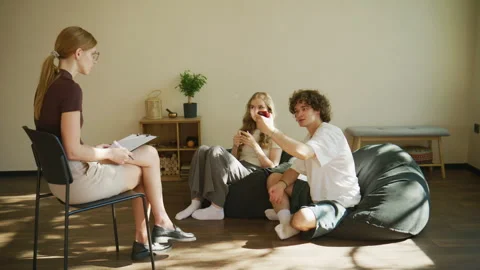A large sunlit room hosts a therapy session, where a man argues with intensity Stock Footage 345009067