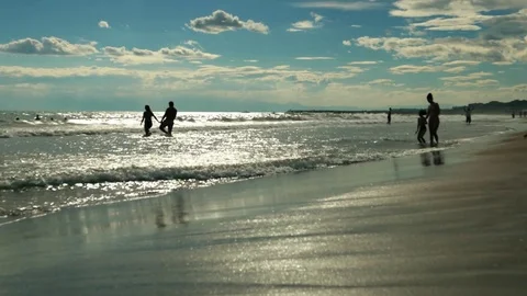 Large sunny sandy ocean beach. Holidaymakers, tourists vacationers in sea waves Stock Footage 77917211