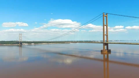 Large suspension bridge spans wide muddy river Vidéo 343532395