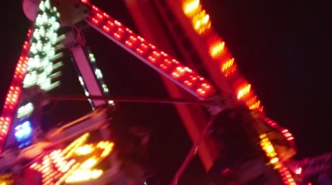 Large swinging ride in motion with people screaming at night Stock Footage 44208201