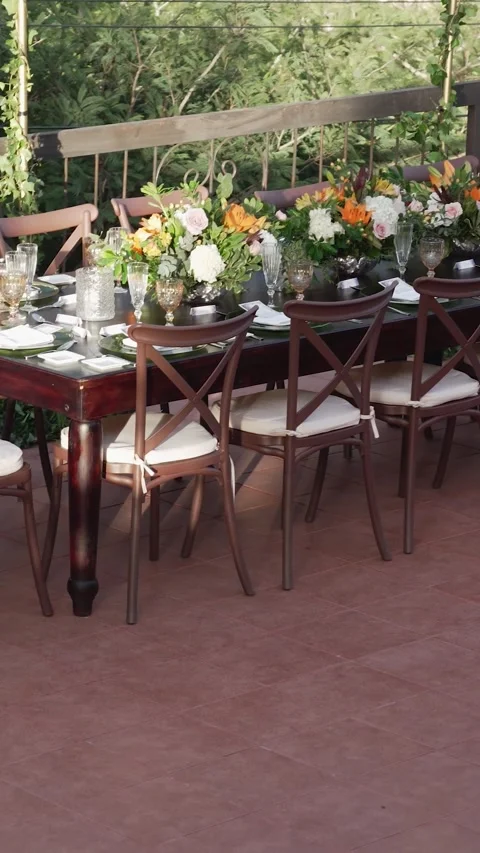 Large table with chairs and a crystal chandelier above it. The table is set for Stock Footage 344985936
