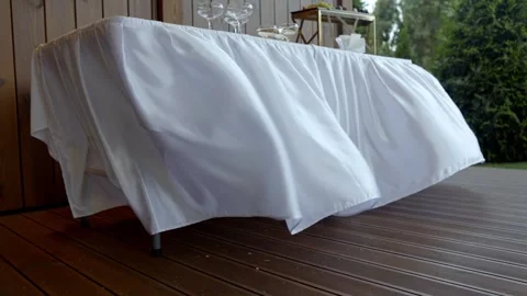 A large table is covered with a large white tablecloth Stock Footage 319382787